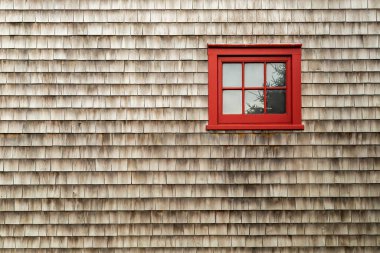 Kırsal ahşap kiremitlere karşı canlı kırmızı bir pencere camı