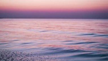 Sakin, rahatlatıcı ve dingin dalgalar Ontario Gölü 'nün üzerindeki güneşin ılık renklerini yansıtıyor..