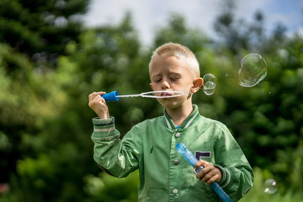 Lille pojken blåser såpbubblor — Stockfoto