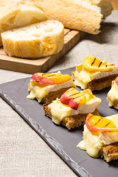 Canapes with grilled brie and nectarine — Stock Photo, Image