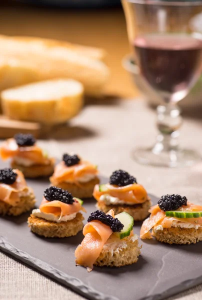 Canapés de salmão defumado com creme de leite e caviar — Fotografia de Stock
