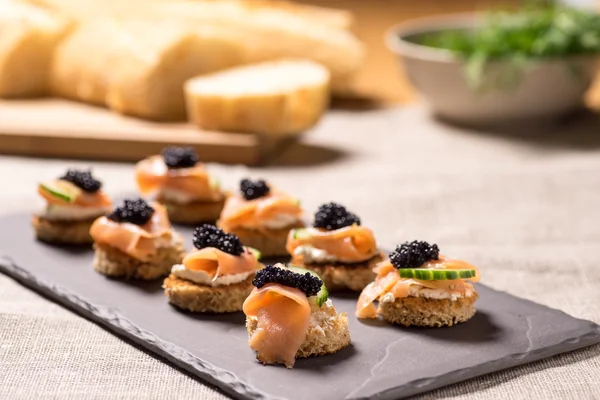 Canapés de salmão defumado com creme de leite e caviar — Fotografia de Stock