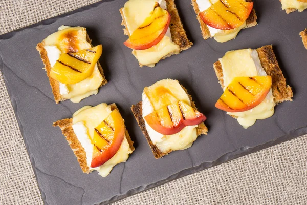 Canapes with grilled brie and nectarine — Stock Photo, Image