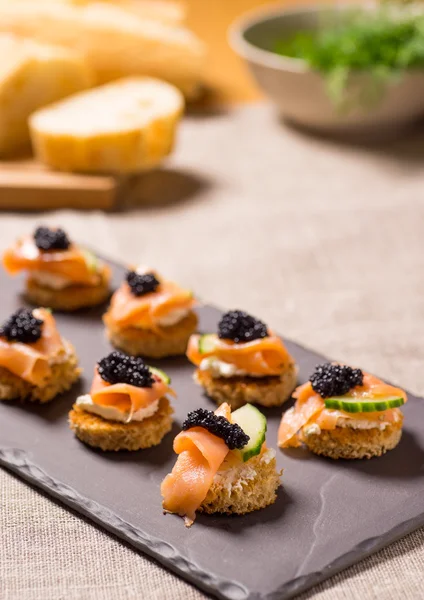 Rökt lax kanapéer med creme fraiche och kaviar — Stockfoto