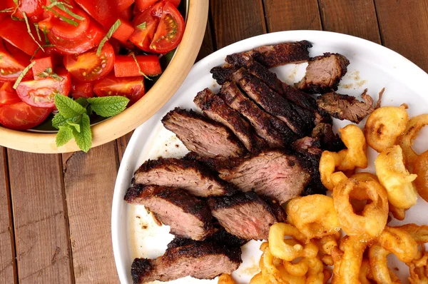Flank Steak mit Pommes Zwiebelringe und Salat — Stockfoto