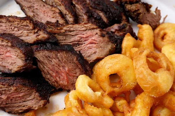 Bife flanco com batatas fritas anéis de cebola — Fotografia de Stock