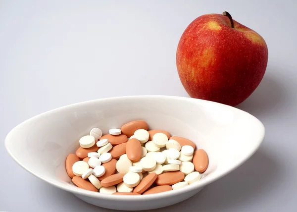 Pastillas medicinales vs manzana saludable —  Fotos de Stock