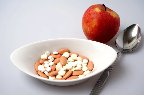 Medicine pills vs healthy apple — Stock Photo, Image