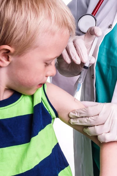 Kleine jongen wordt een injectie gegeven door de huisarts — Stockfoto