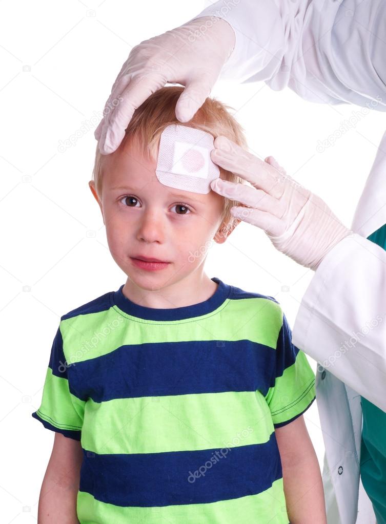 Boy has injury on forehead and gets help by the Doctor