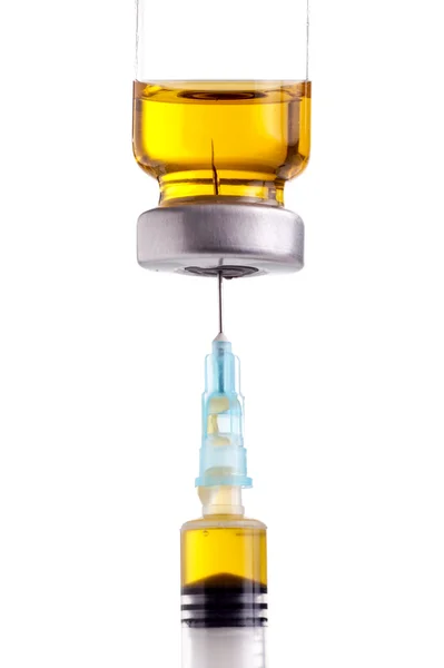 Шприц, наполненный желтой жидкостью из пузырька с лекарством — стоковое фото
