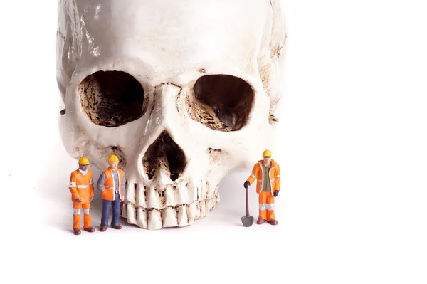 Skull and small workers — Stock Photo, Image