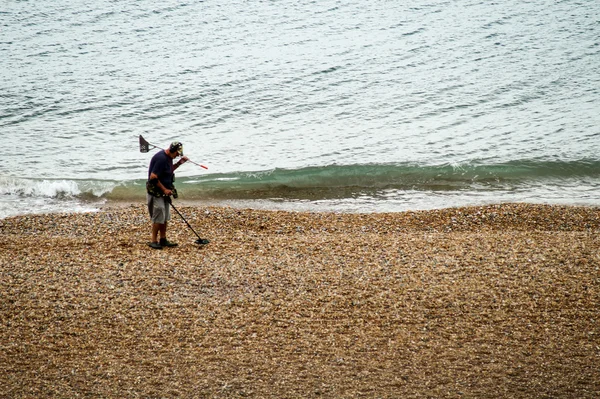 Homem com detector de metais procura na praia — Fotografia de Stock