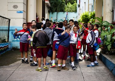 group with schoolchildren standing in front of their school