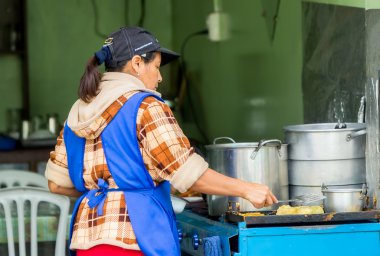 Latin Woman Cooking On The Street clipart