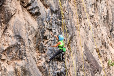 Genç kız bir dikey kaya duvarı tırmanışı