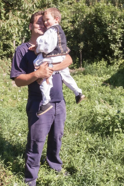 Glückliches Bauernkind in den Armen seines Vaters — Stockfoto