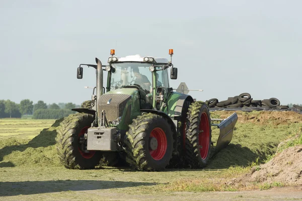 Silagem com um grande tractor — Fotografia de Stock