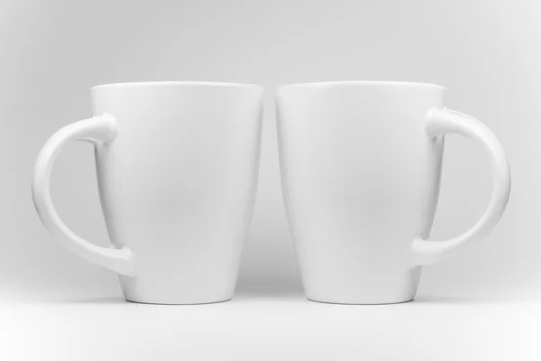 Two white mugs in a mirrored arrangement — Stock Photo, Image