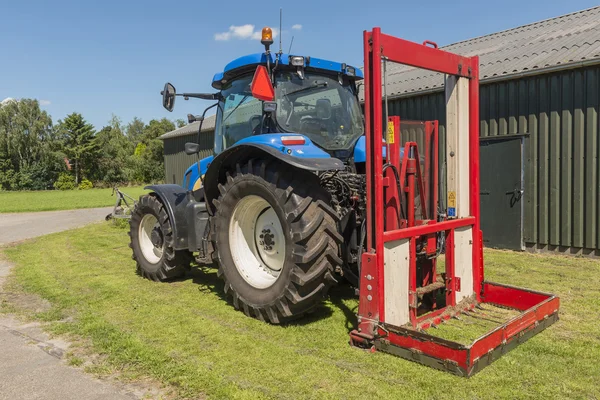 Modrý traktor s červenou bale výřezu — Stock fotografie