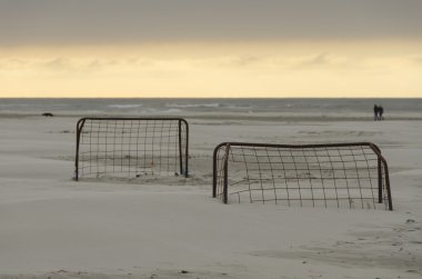 Günbatımında bir plajda futbol gol
