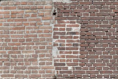 Tamir edilmiş bir duvarda, Hollanda 'daki eski bir binaya, koyu kırmızı bir zincirle bağlanmış tuğlalarla karşı karşıya.