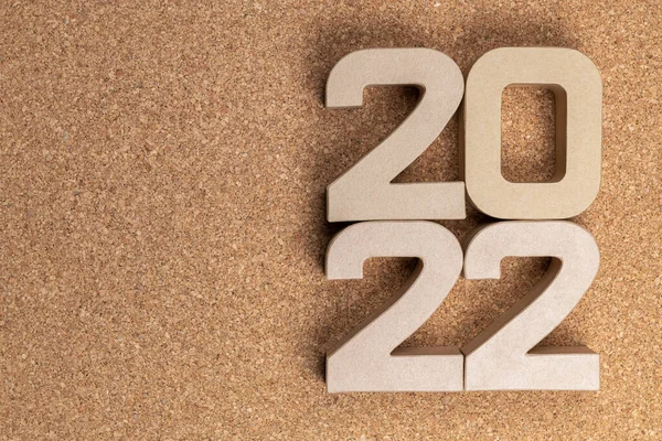 The year twenty twenty-two in large cardboard numbers on a cork background