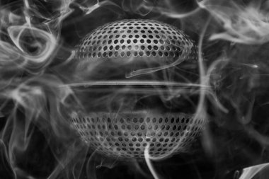 Dumanla kaplanmış yabancı bir nesne gibi dumanlı çay püskürtücüsünün kavramsal siyah ve beyaz arka plan makro fotoğrafı