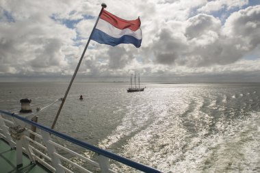 Wadden Sea with Dutch flag as seen from the ferry clipart