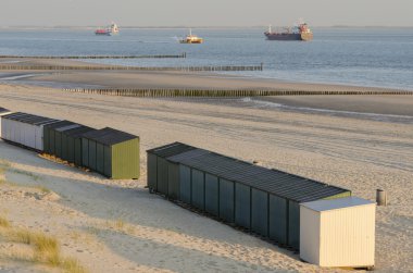 Beach huts on a beach in Zeeland clipart