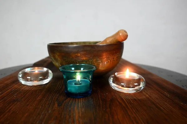 A tibetan singing bowl with lighted candles — Stock Photo, Image