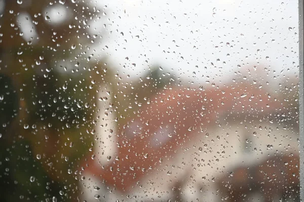 Water drops on a window with a house in the background — Stock Photo, Image