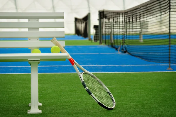 Tenis raketi ve tenis topları kapalı tenis merkezinde.