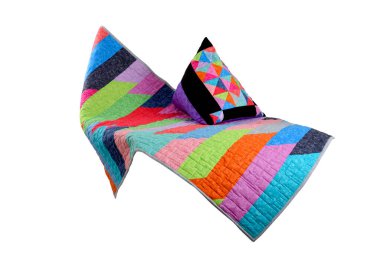 Beyaz arka planda yamalı yorgan ve yastık. Yamalı battaniye. El yapımı. Beyaz arkaplandaki yama çalışması yorganı.