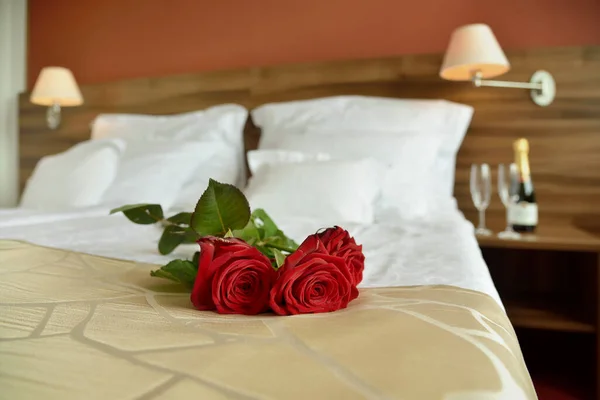 Romantic getaway with roses on bed and fluffy pillows background