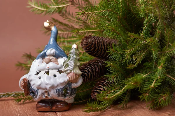 Санта Клаус Игрушка Елкой Ветки Конусами Коричневом Фоне — стоковое фото