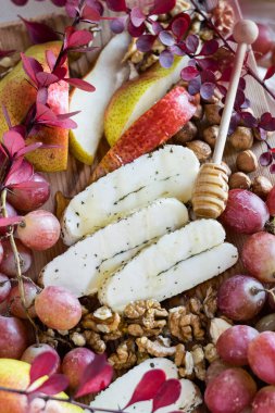 Bal, fındık, üzüm ve armut dilimli dilimlenmiş halloumi peyniri. Tahta tahtada, seçici odaklanma, yakın plan..
