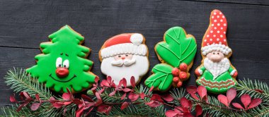 Siyah ahşap masada Noel oyuncakları şeklinde zencefilli kurabiyeler. Yeni yıl, Noel konsepti