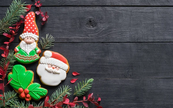 Noel 'de ev yapımı zencefilli kurabiye cücesi ve Noel Baba' yı siyah ahşap masada, kopya uzayda. Yeni yıl, Noel konsepti