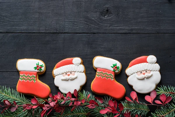 Siyah ahşap masada Noel oyuncakları şeklinde zencefilli kurabiyeler. Yeni yıl, Noel konsepti