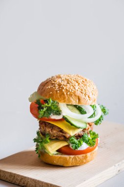 Gri arka planda leziz hamburger, seçici odaklanma, dikey yönelim