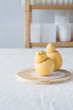 Açık kırsal arka planda kesme tahtasında taze İtalyan peyniri caciocavallo, seçici odak.