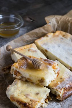 Kuru üzümlü ve ballı süzme peynir güveci ahşap bir masanın üzerinde. Geleneksel Rus tatlı zapekankası
