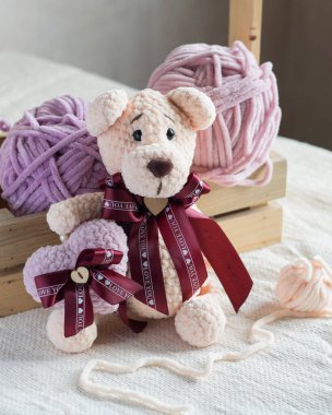 Örgü ören sevimli bej bir ayı. İçinde kalp ve el yapımı bir oyuncak var.