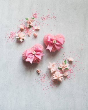 Gri arka planda iki aşk örülmüş pembe kalp, Sevgililer Günü kartı konsepti