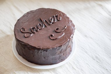 Kayısı reçeli çikolatalı bir gateau ve beyaz keten arka planda çikolatalı krema. Seçici odak