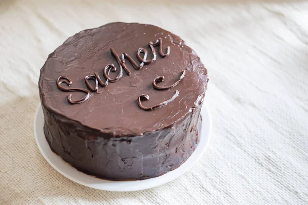 Kayısı reçeli çikolatalı bir gateau ve beyaz keten arka planda çikolatalı krema. Seçici odak