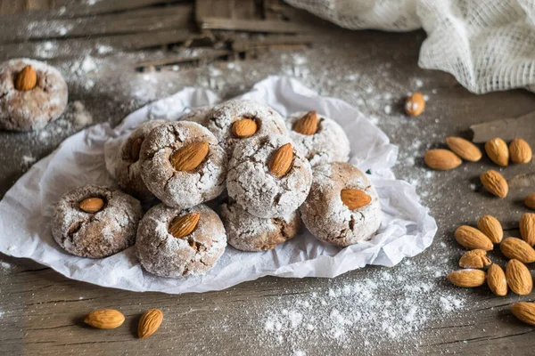 Amaretti, geleneksel İtalyan kurabiyeleri ve ahşap arka planda badem. Seçici odak