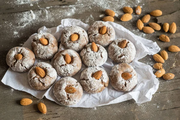 Amaretti, geleneksel İtalyan kurabiyeleri ve ahşap arka planda badem. Seçici odak