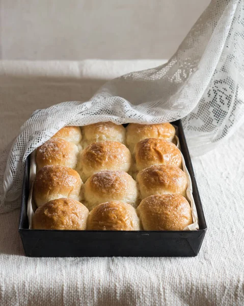 Ev yapımı ekmek ruloları, keten masa örtüsünün üzerinde teneke kalıplar. Seçici odak